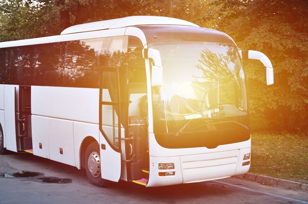 White tourist bus for excursions. The bus is parked in a parking lot near the park